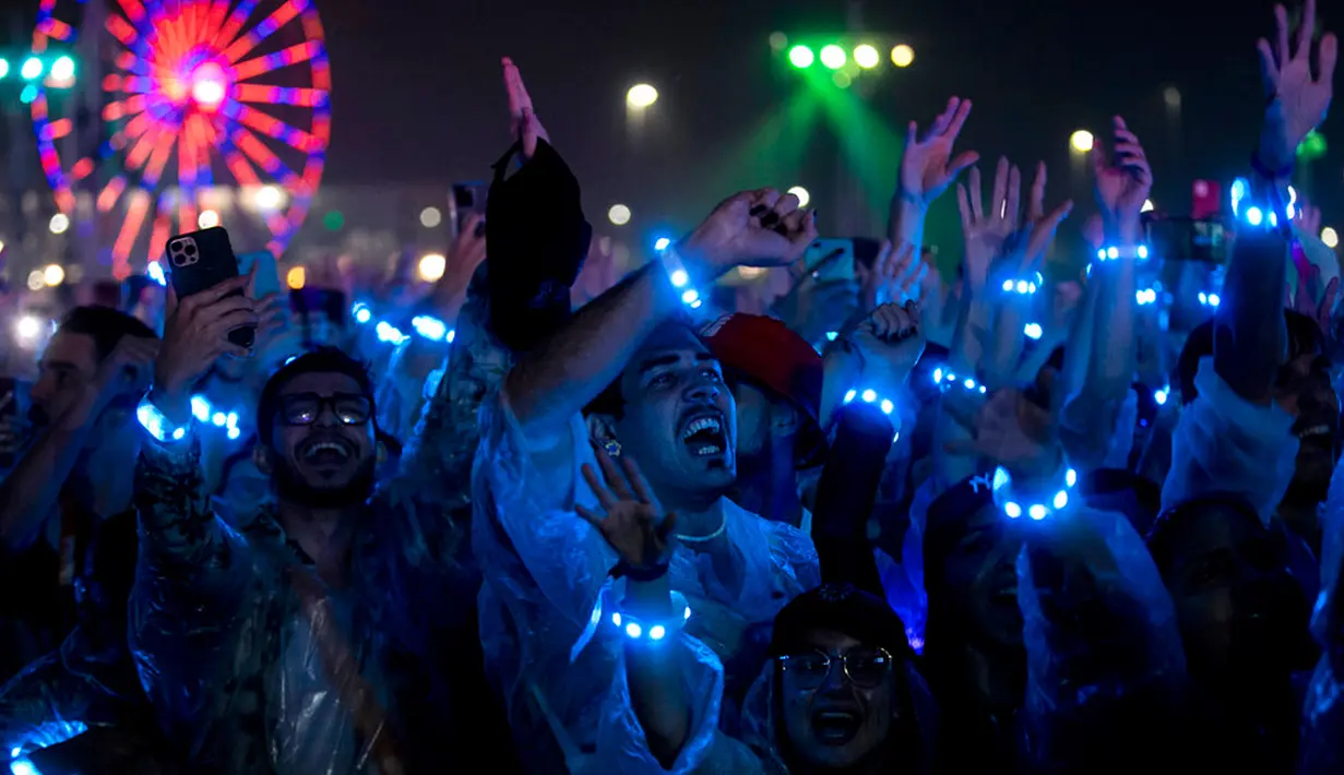 Penonton bersorak saat menonton penampilan band rock Inggris Coldplay pada festival musik Rock in Rio di Rio de Janeiro, Brasil, Minggu (11/9/2022). Coldplay membagikan gelang yang dapat berubah warna dan berkedip mengikuti alunan musik kepada penonton. (AP Photo/Bruna Prado)