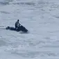 Peselancar Jerman Sebastian Steudtner mengendarai jet ski untuk menyelamatkan rekan setimnya Maya Gabeira setelah terjatuh dalam ombak saat Nazare Tow Surfing Challenge di Praia do Norte atau Pantai Utara, Nazare, Portugal, Selasa (11/2/2020). (AP Photo/Armando Franca)