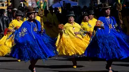 Sejumlah wanita mengenakan kostum menari dalam pawai "Morenada" di La Paz, Bolivia (26/5). Ribuan penari berkumpul melakukan pawai sebagai ucapan terima kasih mereka kepada para dewa. (AP/Juan Karita)