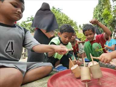 Anak-anak bermain permainan tradisional gasing di RPTRA Melati Duri Pulo, Jakarta, Sabtu (13/10). Traditional Games Returns (TGR) mengampanyekan permainan tradisional dengan mengusung tema "Millenials". (Liputan6.com/Herman Zakharia)