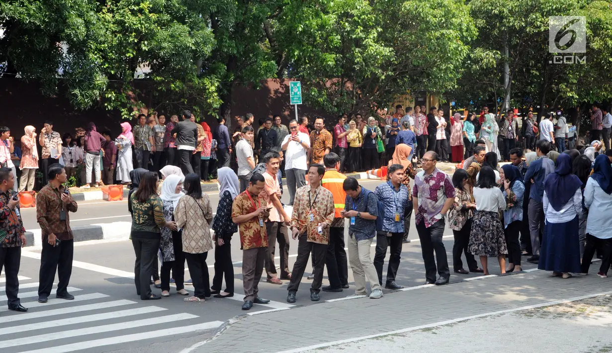 Karyawan berada di luar gedung KPK setelah proses evakuasi ketika simulasi penanggulangan kebakaran, Jakarta, Jumat (14/9). Kegiatan itu untuk memberikan pelatihan dan edukasi kepada seluruh pegawai yang berada di gedung KPK (Merdeka.com/Dwi Narwoko)