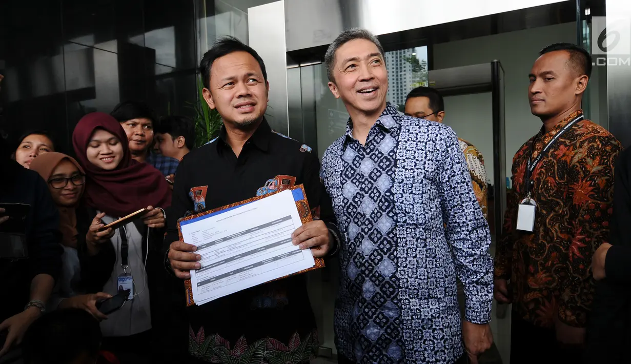 Pasangan Balon Wali Kota dan Wakil Wali Kota Bogor, Bima Arya-Dedie A Rachim menunjukkan bukti pelaporan LHKPN di gedung KPK, Jakarta, Jumat (19/1). Keduanya datang untuk menyerahkan LHKPN. (Liputan6.com/Helmi Fithriansyah)