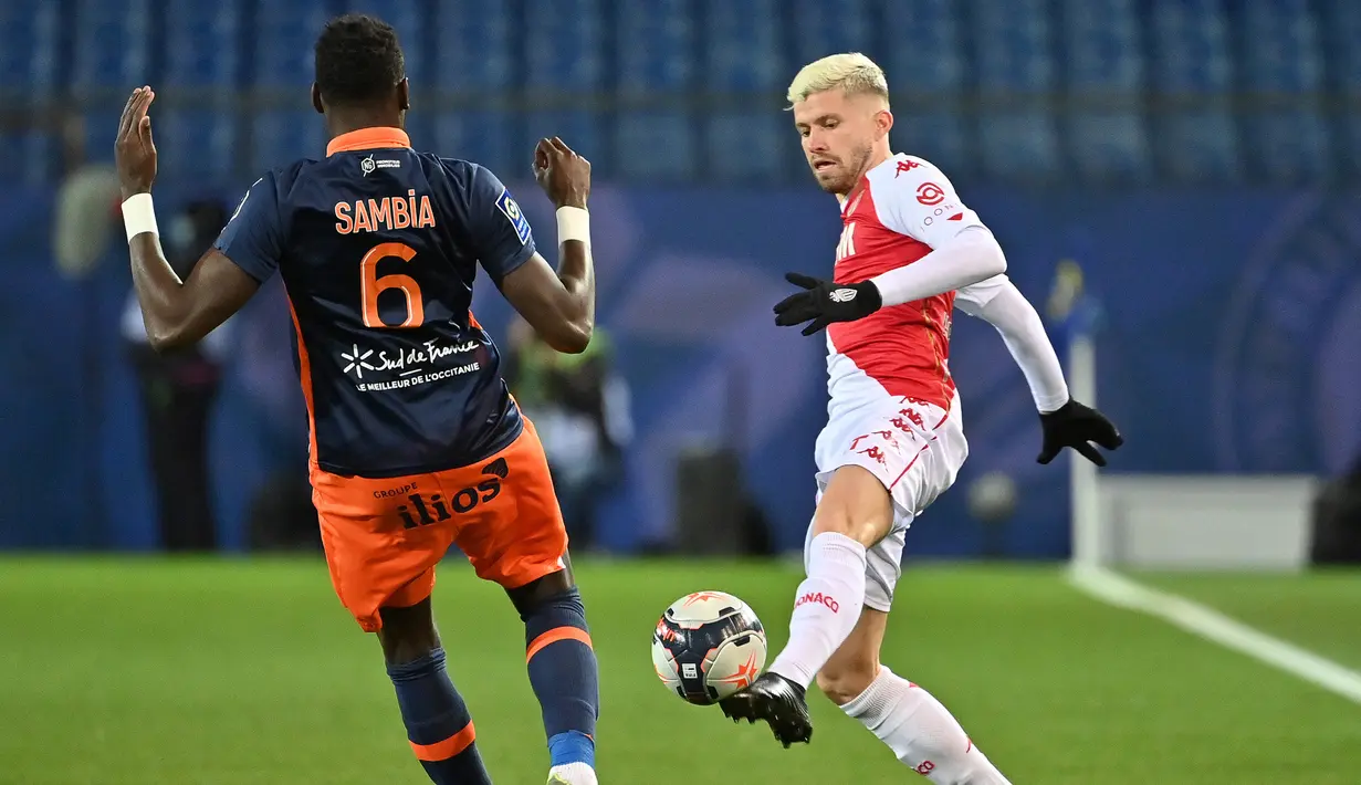 Bek AS Monaco, Caio Henrique (kanan) menguasai bola di hadapan bek Montpellier, Junior Sambia dalam laga lanjutan Liga Prancis 2020/21 pekan ke-20 di Mosson Stadium, Montpellier, Jumat (15/1/2021). AS Monaco menang 3-2 atas Montpellier. (AFP/Pascal Guyot)