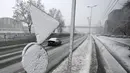 Mobil melintas di jalan saat badai salju di Beograd, Serbia, Minggu (12/12/2021). Banyak daerah di seluruh negeri melaporkan pemadaman listrik dan kerusakan bangunan akibat pohon tumbang.  (AP Photo/Darko Vojinovic)