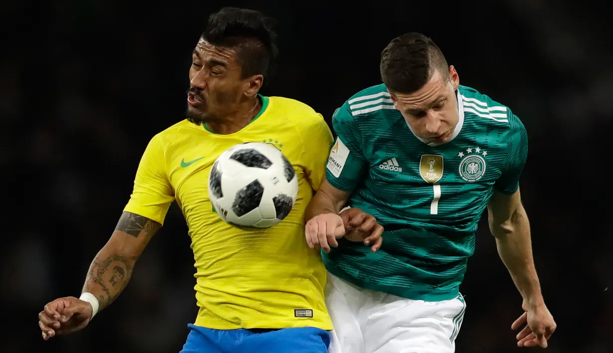 Pemain timnas Brasil,  Paulinho berebut bola dengan pemain timnas Jerman, Julian Draxler dalam laga uji coba di Olympiastadion Berlin, Selasa (27/3). Brasil sukses menaklukkan Jerman dengan skor 1-0. (AP Photo/Michael Sohn)