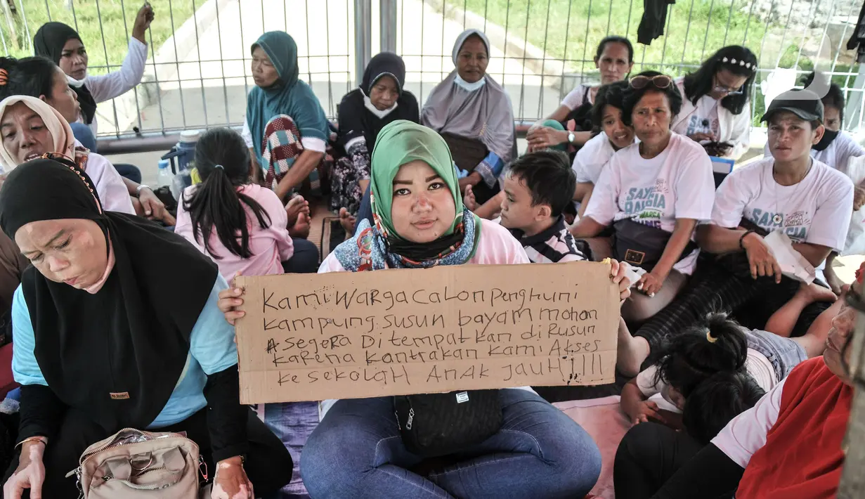 Warga mengangkat poster bertuliskan tuntutan saat berunjuk rasa dengan mendiami tenda pengungsian di depan gerbang Kampung Susun Bayam, Jakarta Utara, Senin (21/11/2022). Aksi tersebut dilakukan untuk menagih janji PT Jakpro dan Pemprov DKI Jakarta agar warga bisa segera menempati Kampung Susun Bayam secepatnya. (merdeka.com/Iqbal S. Nugroho)