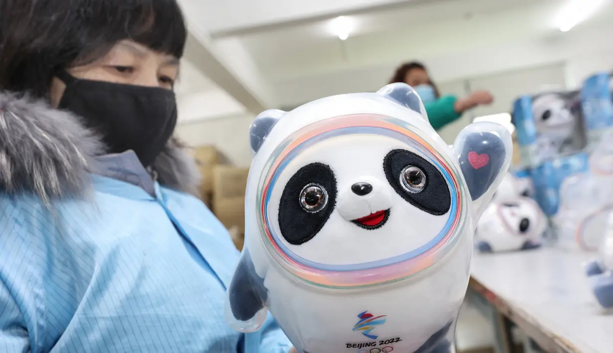 Seorang karyawan mengerjakan boneka  maskot Olimpiade Musim Dingin Beijing 2022 Bing Dwen Dwen di salah satu pabrik di Nantong, Jiangsu Timur, China (8/2/2022). (AFP Photo/STR)