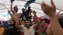 Para migran merayakan di dek kapal penjaga pantai LSM Spanyol Open Arms setelah pengumuman dari kru bahwa Italia telah memberikan akses kapal untuk berlabuh di pelabuhan, setelah operasi penyelamatan di zona perairan internasional di laut Mediterania, Rabu, 21 September 2022. (AP/Petros Karadjias)