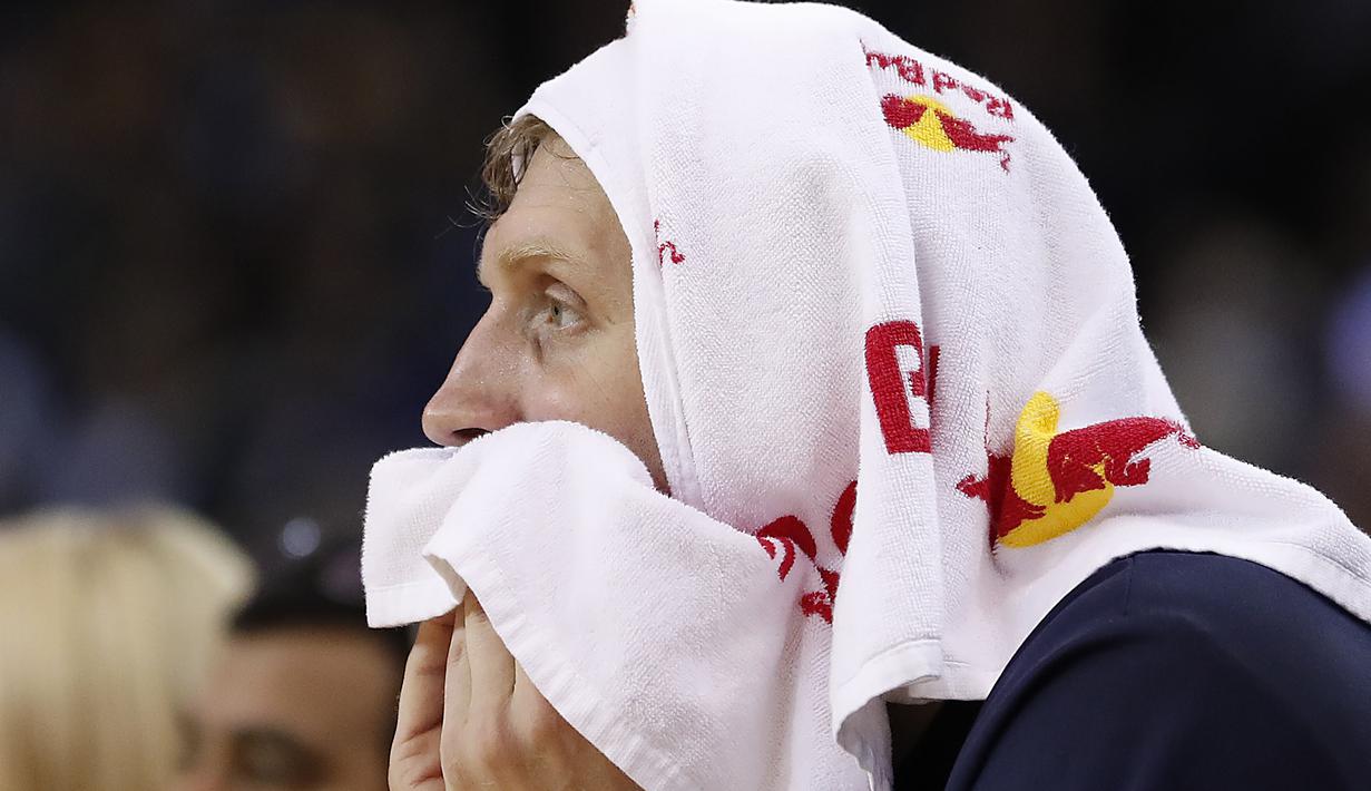 Pemain Dallas Mavericks, Dirk Nowitzki duduk terpaku dibangku pemain cadangan saat timnya kalah dari Warriors pada laga NBA basketball game  di Oakland, California, (30/12/2016). Warriors menang 108-99. (AP/Tony Avelar)