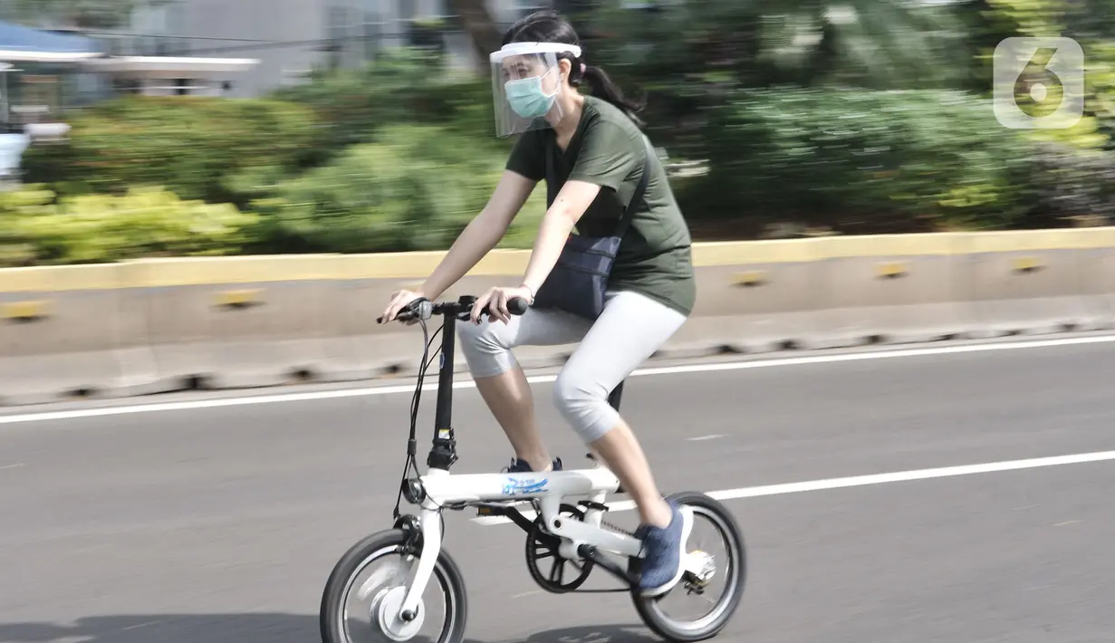 Warga mengendarai sepeda saat kegiatan Car Free Day (CFD) di Kawasan Sudirman, Jakarta, Minggu (21/6/2020). Pada CFD pertama di masa PSBB Transisi, warga Ibu Kota terlihat lebih memilih bersepeda sebagai sarana olahraga dengan tetap menerapkan protokol kesehatan Covid-19. (merdeka.com/Iqbal Nugroho)