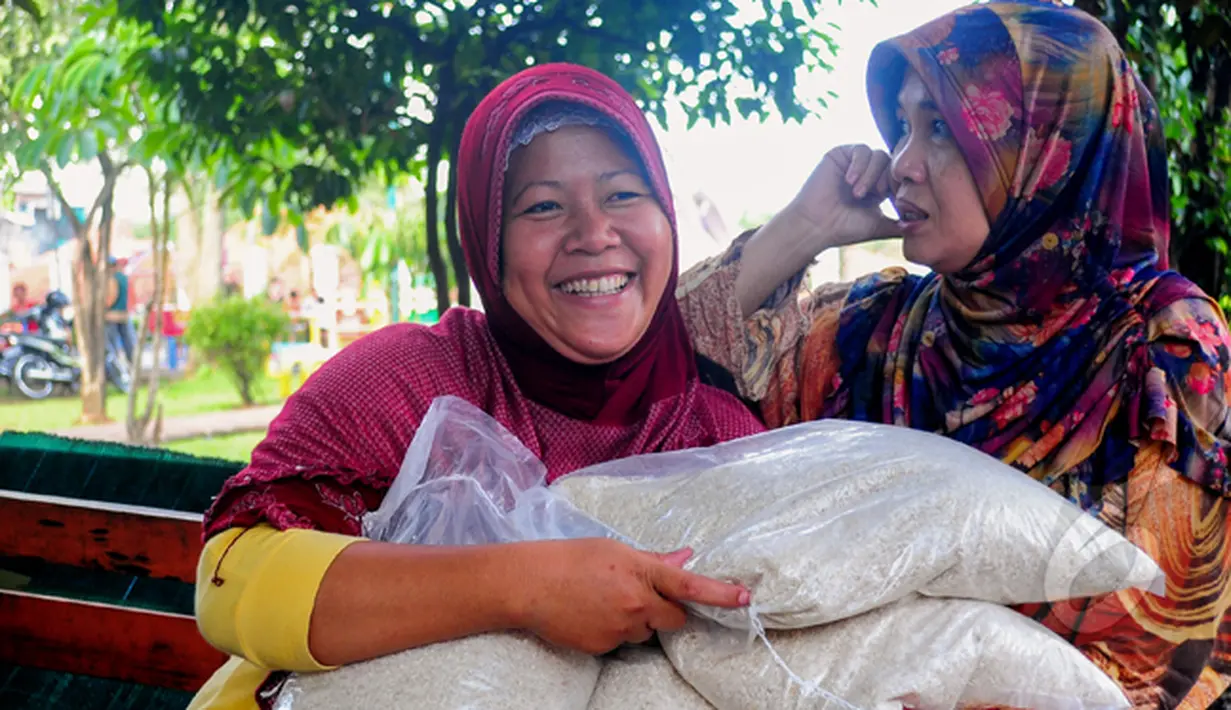 Kegembiraan terpancar usai mendapat beras saat operasi pasar beras oleh BULOG di Lenteng Agung, Jakarta, Senin (2/3/2015). Operasi ini digelar sebagai upaya menurunkan harga beras yang terus naik.(Liputan6.com/Yoppy Renato)