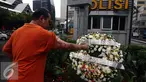 Polisi Korban Bom Thamrin Aiptu Denny Maheu, malakukan tabur bunga saat aksi damai "Peringatan 1 Tahun Tragedi Bom Thamrin 14 Januari 2016", di TKP Pos Polisi Perempatan Sarinah, Jalan Thamrin, Jakarta, Sabtu (14/1). (Liputan6.com/JohanTallo)