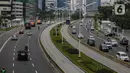 Arus lalu lintas kendaraan di Jalan Sudirman, Jakarta, Senin (13/4/2020). Hari ke-4 penerapan Pembatasan Sosial Berskala Besar (PSBB) di DKI yang dimulai sejak 10 April hingga 23 April 2020, arus lalu lintas di ruas jalan protokol  tersebut masih ramai kendaraan. (Liputan6.com/Faizal Fanani)