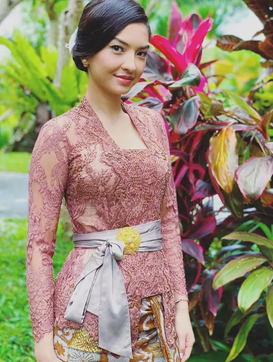 Lagi, Raline Shah tampil menawan dalam balutan kebaya Bali. Kebaya Bali sederhana bernuansa merah muda-ungu ini dipadu dengan kain Bali dengan sentuhan warna emas yang serasi. Bros emas disematkan di selendang abu-abu yang diikatkan di pinggangnya. [Foto: Instagram/ralineshah]