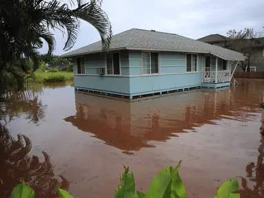 Sebuah rumah di Jalan Haleiwa dikelilingi air banjir di Hawaii (9/3/2021). Negara bagian Hawaii Amerika Serikat (AS) kini dalam status keadaan darurat. Ini diumumkan langsung Gubernur David Ige, Selasa (9/3/2021) waktu setempat. (Jamm Aquino/Honolulu Star-Advertiser via AP)