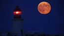 Supermoon terbit di belakang mercusuar di Valletta Grand Harbour, Malta, Selasa (9/9/14). (REUTERS/Darrin Zammit Lupi) 