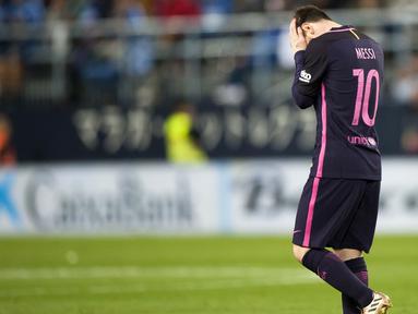 Ekspresi bintang FC Barcelona, Lionel Messi yang memegang kepalanya setelah timnya kalah dari Malaga pada lanjutan La Liga Spanyol di di Estadio La Rosaleda (8/4/2017). Barcelona kalah 0-2 dari Malaga. (AP/Daniel Tejedor)