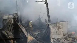 Petugas pemadam berusaha memadamkan api yang membakar pemukiman warga di kawasan Jalan Kebayoran Lama, Jakarta, Minggu (30/10/2022). Kebakaran terjadi persisi di belakang RS Permata Hijau di Jalan Raya Kebayoran Lama. Total ada 100 personel yang turun ke lokasi memadamkan api. (Liputan6.com/Helmi Fithriansyah)