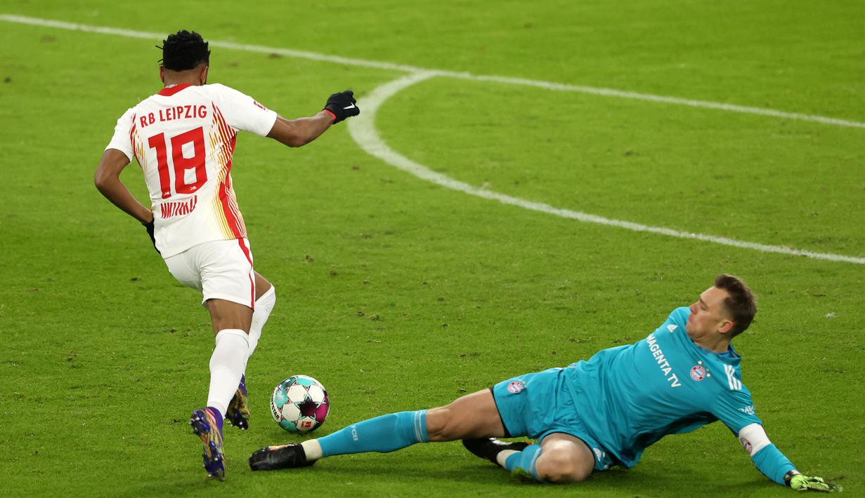 Gelandang RB Leipzig, Christopher Nkunku, melewati kiper Bayern Munich, Manuel Neuer, untuk mencetak gol pertama RB Leipzig dalam laga lanjutan Liga Jerman pekan ke-10 di Allianz Arena, Sabtu (5/12/2020). RB Leipzig bermain imbang 3-3 dengan Bayern Munich. (AFP/Alexander Hassenstein/Pool)