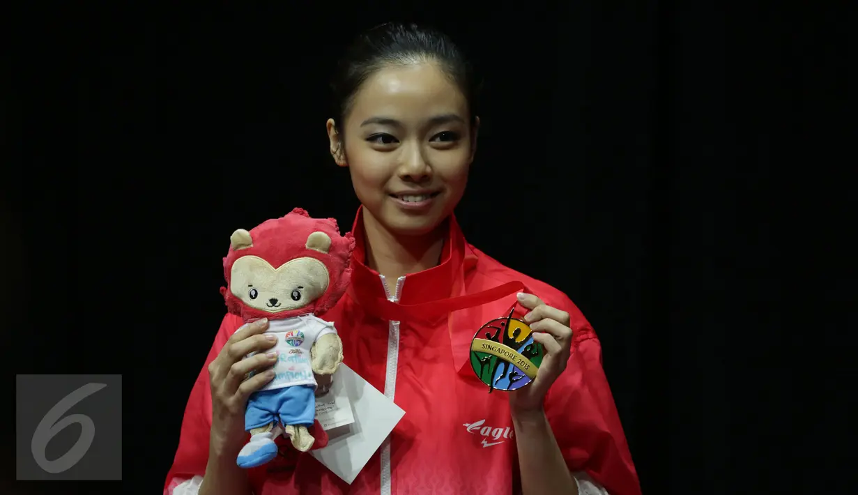 Atlet wushu Indonesia, Lindswell Kwok berfoto usai pengalungan medali SEA Games 2015 di SingaporeExpo, Singapura, Senin (8/6/2015). Lindswell berhasil meraih emas di nomor pedang TaijiJian dengan nilai 9.73 poin. (Liputan6.com/Helmi Fithriansyah)