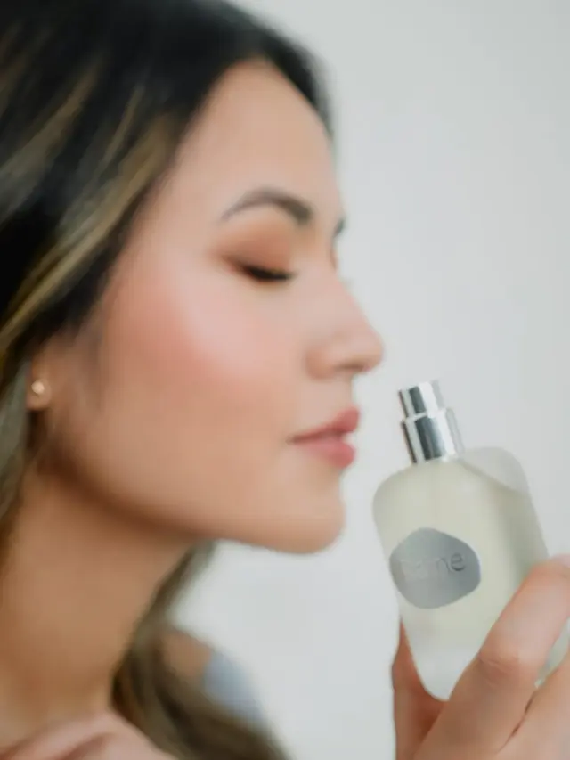 Ilustrasi Raisa mencium keharuman parfum Ambivert/Raine Beauty