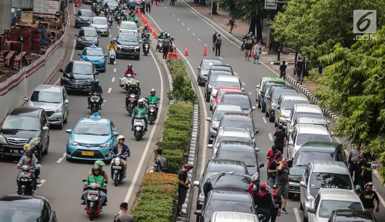 Sejumlah mobil pengemudi online menutup jalur lambat saat mereka menggelar demo di kantor pusat Grab kawasan Kuningan, Jakarta, Senin (29/10). Akibat aksi tersebut, kemacaten parah terjadi dari arah Mampang menuju Menteng. (Liputan6.com/Faizal Fanani)