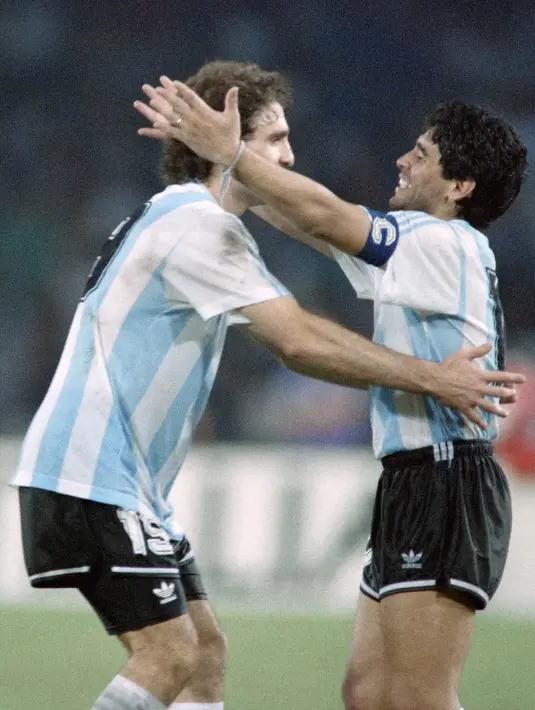 Pemain sepak bola Argentina Diego Maradona (kanan) dan Oscar Ruggeri merayakan kemenangan pada semifinal Piala Dunia di Naples, Italia, 30 Juli 1990. Diego Maradona dikabarkan menutup mata di Tigre, sebuah kawasan di Buenos Aires, ibu kota Argentina. (AFP PHOTO/PATRICK HERTZOG)