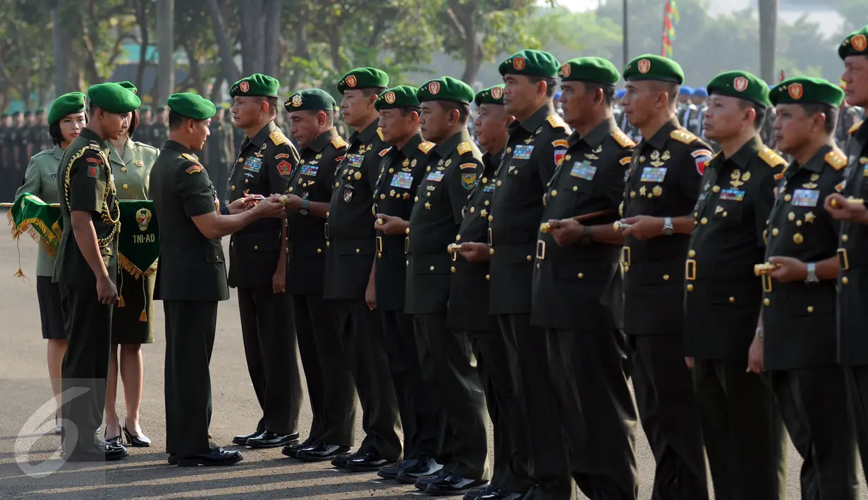 KASAD Jenderal TNI Mulyono menyerahkan tongkat komando kepada Panglima Kostrad, Mayjen TNI Edy Rahmaya di saat upacara serah terima jabatan di Markas Divisi Infanteri I Kostrad, Cilodong, Jawa Barat, Jumat (31/7/2015). (Liputan6.com/Helmi Fithriansyah)