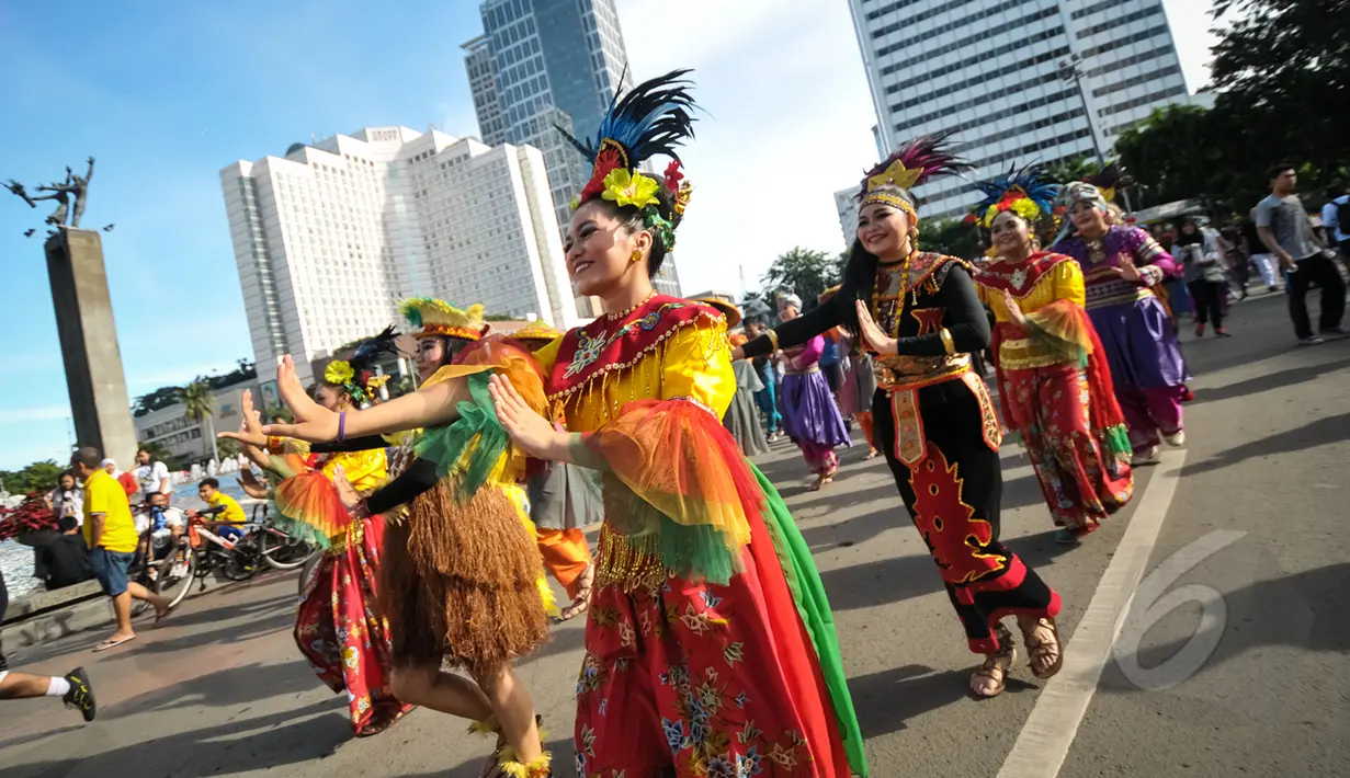 Kelompok seniman T-Ta asal Universitas Paramadina menari saat car free day di Bundara HI, Jakarta, Minggu (26/4/2015). Mereka meminta sumbangan kepada warga untuk mengikuti Interntional Folklore Festival di Spanyol. (Liputan6.com/Faizal Fanani)
