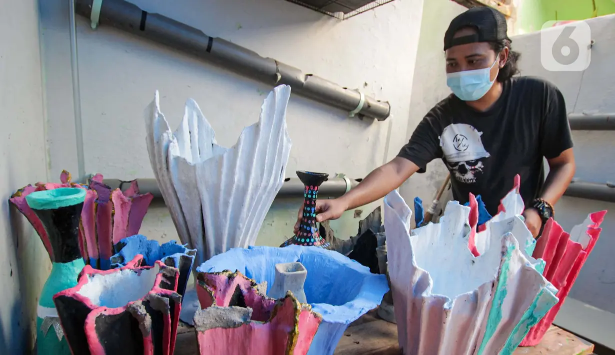 Seorang anak muda menyelesaikan pembuatan pot tanaman berbahan dasar kain bekas di  Cibodas, Kota Tangerang, Minggu (3/10/2021). Para pemuda ini memanfaatkan PPKM untuk membuat Pot tanaman daur ulang yang dipasarkan mulai harga Rp. 30 ribu hingga Rp. 80 ribu. (Liputan6.com/Angga Yuniar)