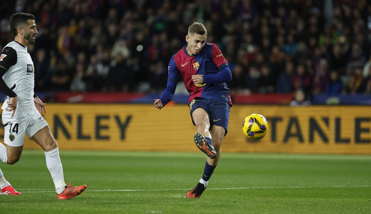 Pemain Barcelona, Fermin Lopez mencetak gol ke gawang Valencia pada laga lanjutan Liga Spanyol 2024/2025 di Estadi Olimpic Lluis Companys, Barcelona, Spanyol, Senin (27/01/2025) dini hari WIB. (AP Photo/Joan Monfort)