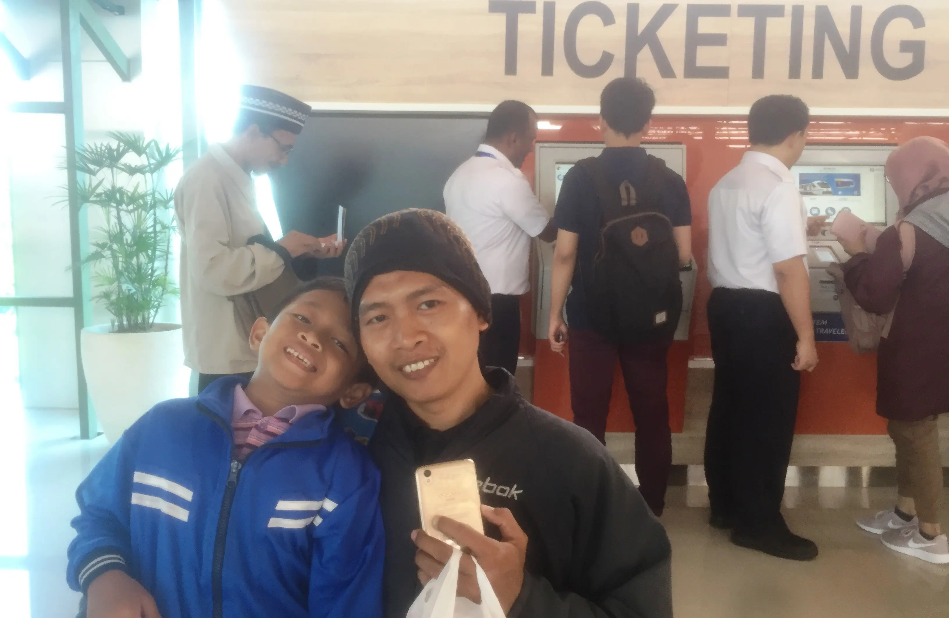 Abu Khori (35), warga Bekasi, sengaja membeli dua tiket menuju Bandara Soekarno-Hatta bersama anaknya untuk menjajal kereta bandara di hari pertama. (Liputan6.com/Delvira Chaerani Hutabarat)