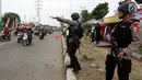 Polisi bersenjata berjaga sambil mengatur lalu lintas di jalur pantura Jenderal Ahmad Yani, Bypass, Kota Cirebon, Kamis (22/6). Selama arus mudik, pasukan bersenjata lengkap diterjunkan untuk mengantisipasi gangguan keamanan.  (Liputan6.com/Johan Tallo)