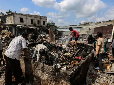 Warga memilah barang pasca terjadi kebakaran di Pasar Ciputat, Tangerang Selatan, Kamis (12/5/2022). Puluhan lapak pedagang di Pasar Ciputat, Kota Tangerang Selatan (Tangsel), Banten terbakar pada Rabu (11/5/2022) sore. Kebakaran diduga terjadi akibat adanya arus pendek atau korsleting listrik. (Liputan6.com/Johan Tallo)