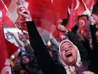 Seorang wanita merayakan kemenangan Presiden Turki Recep Tayyip Erdogan dalam referendum di dekat markas besar konservatif Partai Keadilan dan Pembangunan (AKP) di Istanbul, Turki (16/4). (AFP Photo / Ozan Kose)