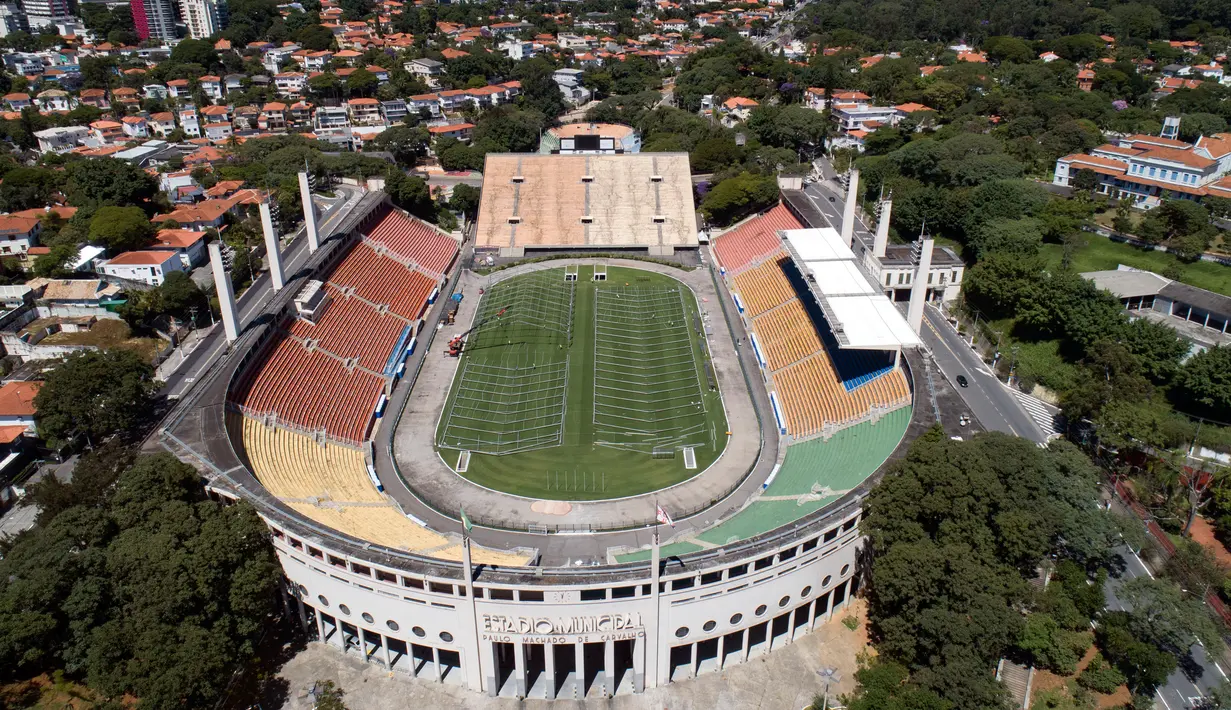 Pekerja membangun rumah sakit darurat bagi pasien terinfeksi Covid-19 di lapangan stadion Pacaembu, di Sao Paulo, Senin (23/3/2020). Sejumlah klub sepakbola papan atas Brasil meminjamkan stadion ke otoritas setempat untuk diubah menjadi rumah sakit atau klinik darurat virus corona. (AP/Andre Penner)
