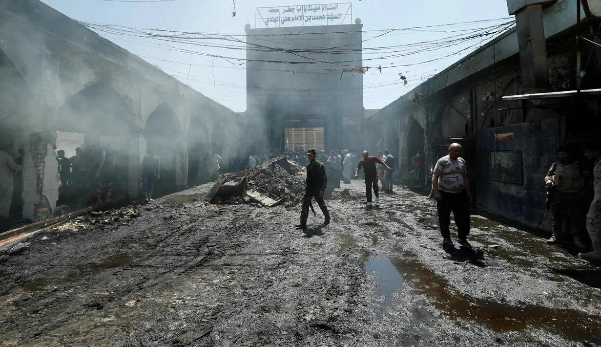Orang-orang berkumpul melihat kondisi masjid yang terdapat makam Sayid Muhammad bin Ali al-Hadi di Balad usai terkena serangan bom bunuh diri, Baghdad, Irak (8/7). Dikabarkan 30 orang tewas dalam peristiwa tersebut. (REUTERS / Thaier Al-Sudani)