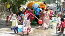 Warga membawa air bersih bantuan pemerintah dalam wadah plastik di perkampungan kumuh di Secunderabad, Hyderabad, India, Rabu (20/5/2020). Gelombang panas membuat negara berpenduduk 1,3 miliar tersebut mengalami krisis air bersih. (NOAH SEELAM/AFP)