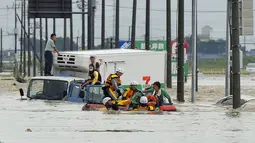Petugas pemadam kebakaran mengevakuasi warga yang terjebak luapan banjir dari Sungai Kinugawa di Joso, prefektur Ibaraki, Jepang, Kamis (10/9). Satu orang hilang dan lebih dari 90 ribu warga diperintahkan untuk mengungsi. (REUTERS/Kyodo)