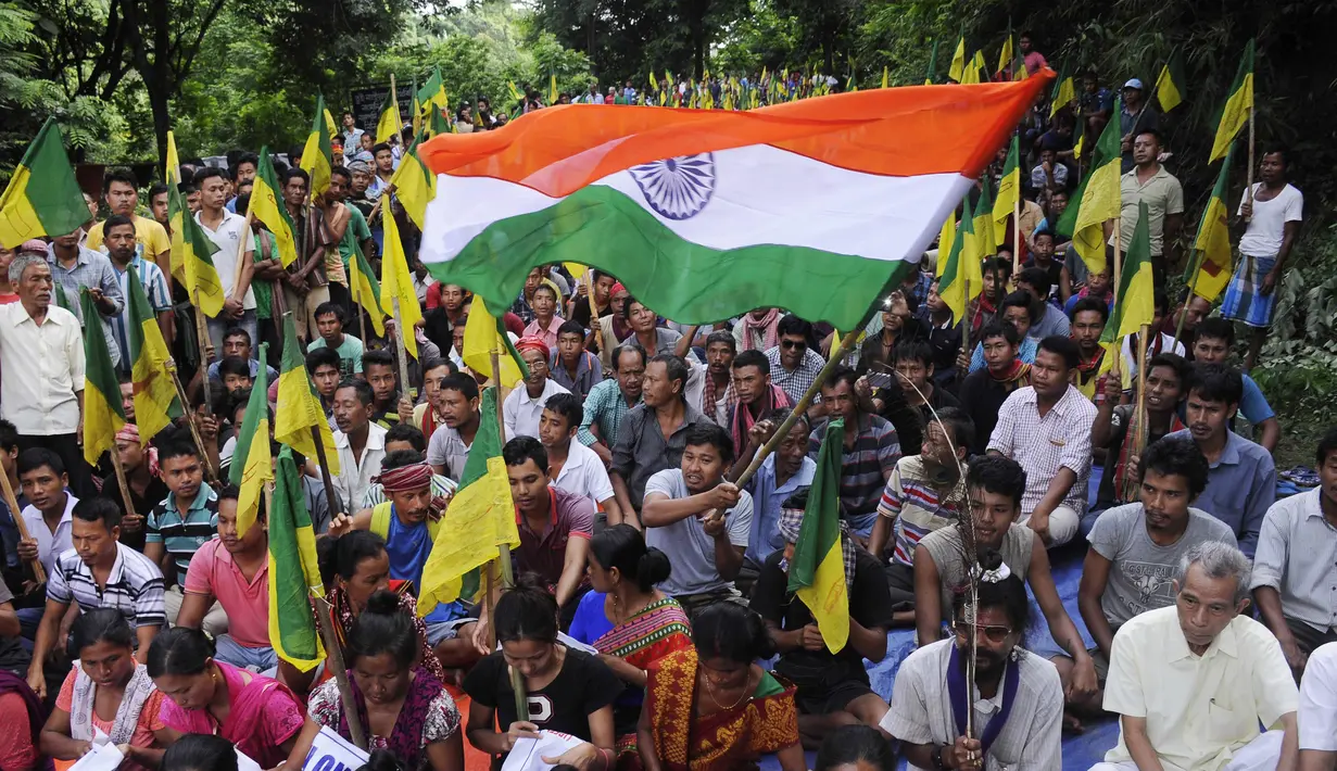 Pengunjuk rasa dari Front Rakyat Pribumi Tripura (IPFT) mengibarkan bendera India saat menggelar demo di Khamtingbari di dekat perbatasan Agartala, India, Senin (10/7). Mereka menuntut negara bagian Tripura terpisah. (AFP Photo/ Arindam Dey)