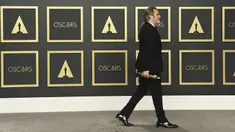 Aktor Joaquin Phoenix berjalan membawa piala Oscar 2020 usai berpose di ruang pers di  Dolby Teater, Los Angeles, Minggu (9/2/2020). Joaquin Phoenix yang memerankan karakter Arthur Fleck dalam film Joker, meraih penghargaan Oscar 2020 untuk kategori aktor terbaik. (AP Photo/Jordan Strauss)