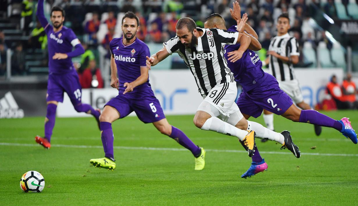 Pemain Juventus, Gonzalo Higuain (tengah) berusaha melewati kepungan pemain Fiorentina pada lanjutan Serie A di Allianz Stadium, Turin, (20/9/2017). Juventus menang 1-0. (AFP/ Alberto Pizzoli)