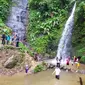 Para pengunjung tengah menikmati sensasi berenang di kawasan wisata alam Curug Candung, Garut-Tasikmalaya, Jawa Barat. (Liputan6.com/Jayadi Supriadin)