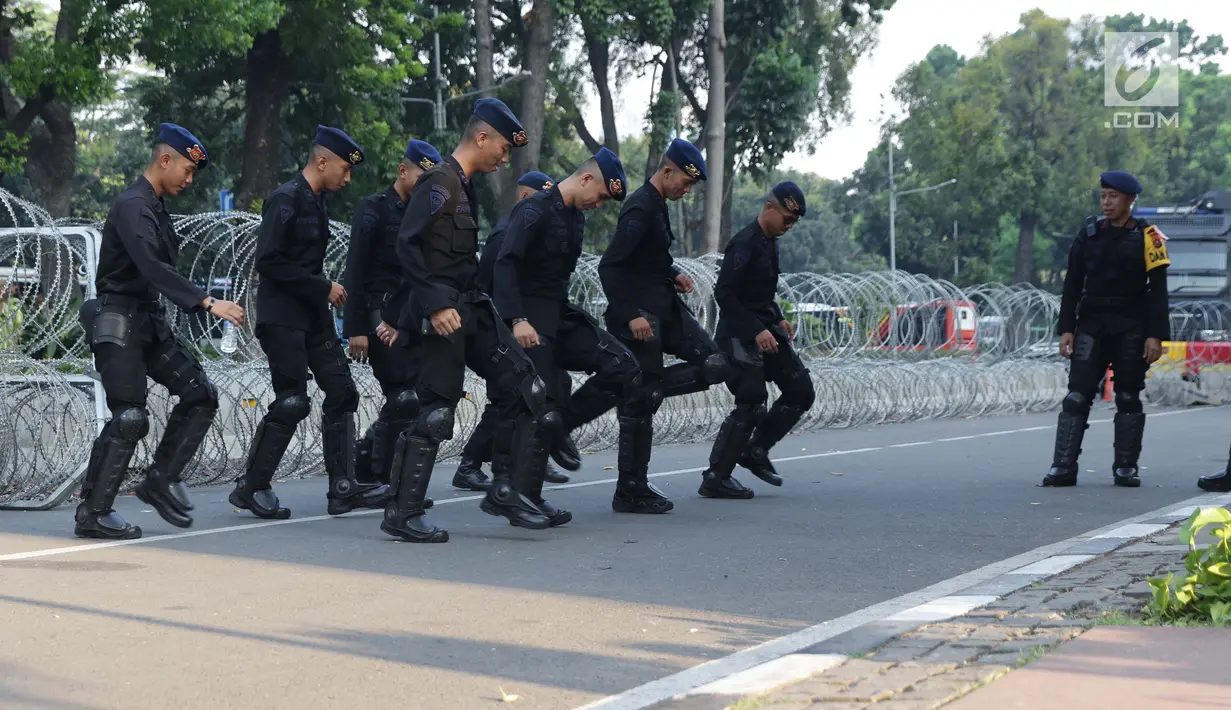 Personel Brimob menari bersama disela-sela berjaga di depan Gedung Mahkamah Konstitusi (MK), Jakarta, Selasa (25/6/2019). Kegiatan ini dilakukan untuk mengusir kejenuhan disela-sela pengamanan Gedung MK jelang sidang pembacaan putusan, Kamis (27/6). (Liputan6.com/Helmi Fithriansyah)