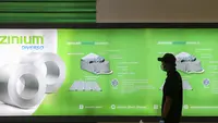 Pengunjung melintas di depan papan booth Zinium Diverso pada pameran IndoBuildTech Expo 2022 di Tangerang (16/11/2022). (Liputan6.com)