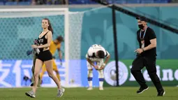 Sejumlah pihak keamanan sebenarnya telah berusaha mengejar wanita tersebut. Namun apa daya, wanita itu berlari dengan cepat dan berhasil mencapai tengah lapangan. (Foto: AP/Pool/Lars Baron)