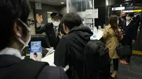 Kepala stasiun membantu pelanggan saat layanan perjalanan dihentikan setelah gempa bumi di stasiun kereta Tokyo di Tokyo, Kamis (17/3/2022) pagi. Gempa kuat Magnitudo 7,3 mengguncang lepas pantai Fukushima di Jepang utara pada hari Rabu (16/3), memicu peringatan tsunami. (AP Photo/Hiro Komae)