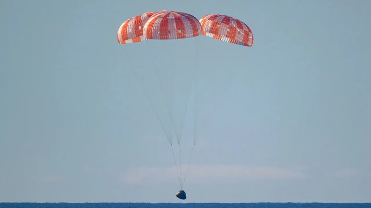 Kapsul Orion milik NASA yang membawa awak misi Artemis II mendekati permukaan Samudra Pasifik untuk mendarat di laut (splashdown) di lepas pantai California, Amerika Serikat, Jumat (10/4/2026).