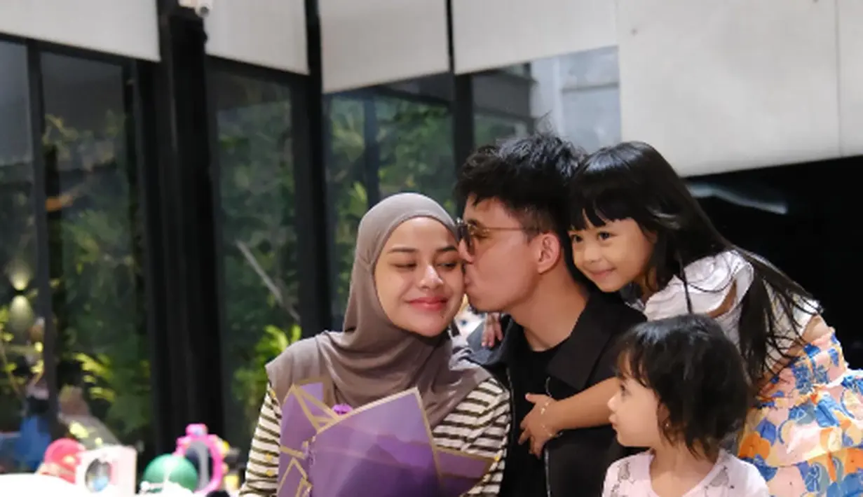 Tampil bare face, Aurel Hermansyah dapat hadiah hand bouquet dari suami dan anak-anak. Ia nampak kenakan striped long sleeve dengan celana jeans longgar dan hijab cokelat [@aurelie.hermansyah]