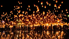 Sejumlah orang melepaskan lampion ke udara saat mereka merayakan festival Yee Peng di Chiang Mai (3/11). Dalam festival ini, ratusan bahkan ribuan orang beramai-ramai menerbangkan lampion ke udara. (AFP Photo/Roberto Schmidt)